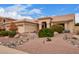 Charming single-story home with a tile roof and desert landscaping including rocks and a spacious three-car garage at 9104 E Hillery Dr, Scottsdale, AZ 85260