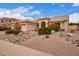 Charming single-story home with a tile roof and desert landscaping including rocks and a spacious three-car garage at 9104 E Hillery Dr, Scottsdale, AZ 85260