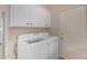 Laundry room featuring white appliances, cabinets and a doorway leading outside at 9104 E Hillery Dr, Scottsdale, AZ 85260