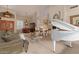 Open-concept living room with a white grand piano, fireplace, and dining area for elegant entertaining at 9104 E Hillery Dr, Scottsdale, AZ 85260