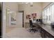 Home office featuring carpet, modern desk, and large window with a bedroom visible through the doorway at 9104 E Hillery Dr, Scottsdale, AZ 85260