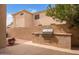 Backyard patio features built-in outdoor kitchen with barbecue and textured stone wall at 9104 E Hillery Dr, Scottsdale, AZ 85260