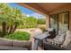 Covered patio with comfortable seating area and view of the landscaped backyard at 9104 E Hillery Dr, Scottsdale, AZ 85260