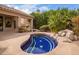 Backyard view of the pool, with stone surround and outdoor kitchen at 9104 E Hillery Dr, Scottsdale, AZ 85260