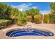 Inviting outdoor pool with blue tiles, rock feature, and lush landscaping at 9104 E Hillery Dr, Scottsdale, AZ 85260