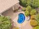 Aerial close up of the backyard pool and patio; the uniquely shaped pool is surrounded by well maintained landscaping and patio at 9104 E Hillery Dr, Scottsdale, AZ 85260