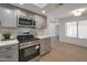 Updated kitchen featuring stainless steel microwave and range oven, and gray cabinets over a light, wood floor at 924 W Boxelder Pl, Chandler, AZ 85225