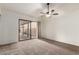 Cozy bedroom with neutral carpet, fan, and sliding door access to a patio at 945 N Pasadena St # 61, Mesa, AZ 85201