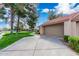 Spacious driveway leading to a two-car garage, complemented by mature trees and landscaping at 945 N Pasadena St # 61, Mesa, AZ 85201