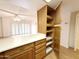 Kitchen featuring a countertop and wood cabinets with open shelves looking into the living room at 10330 W Thunderbird Blvd # B101, Sun City, AZ 85351