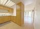 Galley kitchen featuring wood cabinets, white countertops, and access to the living room at 10330 W Thunderbird Blvd # B101, Sun City, AZ 85351