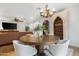 Cozy dining room with round table, stylish chandelier, open to living area at 10406 E Silvertree Dr, Sun Lakes, AZ 85248