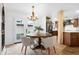 Bright dining room with round table, stylish chandelier, and backyard access at 10406 E Silvertree Dr, Sun Lakes, AZ 85248