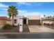 Charming single-story home with desert landscaping, palm tree and a two-car garage in a gated community at 10406 E Silvertree Dr, Sun Lakes, AZ 85248