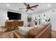 Bright living room features wood-look floors, leather couch, ornate sideboard, and ceiling fan at 10406 E Silvertree Dr, Sun Lakes, AZ 85248