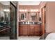 Bathroom featuring double vanity sinks, granite countertops, and a glass-enclosed shower at 10718 W Saratoga Cir, Sun City, AZ 85351