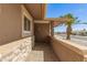 Charming entryway featuring stone accents and a glimpse of the desert landscape under a bright blue sky at 10718 W Saratoga Cir, Sun City, AZ 85351