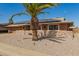 Inviting home with a wide driveway, stone accents, solar panels, and desert landscaping under a clear blue sky at 10718 W Saratoga Cir, Sun City, AZ 85351