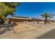 Inviting home with a wide driveway, stone accents, solar panels, and desert landscaping under a clear blue sky at 10718 W Saratoga Cir, Sun City, AZ 85351