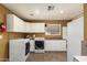 Laundry room featuring white cabinets, modern washer and dryer, and tile floor at 10718 W Saratoga Cir, Sun City, AZ 85351