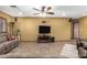 Open living area showcasing tile floors, a ceiling fan, and a flat-screen television for entertainment at 10718 W Saratoga Cir, Sun City, AZ 85351