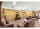 Spacious living room featuring tile flooring and a comfortable seating arrangement with a large screen TV at 10718 W Saratoga Cir, Sun City, AZ 85351