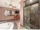 Opulent main bathroom featuring a glass shower, corner tub, double vanity, and tiled floors at 10718 W Saratoga Cir, Sun City, AZ 85351