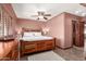 Comfortable main bedroom featuring a ceiling fan and rustic wood furniture at 10718 W Saratoga Cir, Sun City, AZ 85351