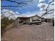 Exterior view of the home with a covered patio, surrounded by desert landscape and a view of the sky at 10997 N Hualapai Dr, Casa Grande, AZ 85122