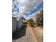 Gravel landscaping and a shed are visible in the backyard with blue skies and clouds above at 10997 N Hualapai Dr, Casa Grande, AZ 85122