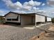 A single story home with a large carport and desert landscaping under a blue sky at 10997 N Hualapai Dr, Casa Grande, AZ 85122