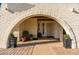 Inviting entrance with brick archway, desert landscaping, and a decorative security door at 11138 W Hatcher Rd, Sun City, AZ 85351