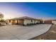 A house with desert landscaping, brick archway, two-car garage, and RV parking, at dusk at 11138 W Hatcher Rd, Sun City, AZ 85351