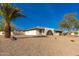 Charming home with desert landscaping, mature palm tree, and a brick archway at 11138 W Hatcher Rd, Sun City, AZ 85351