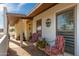 Cozy shaded patio with two comfortable chairs and a view of the front yard at 11138 W Hatcher Rd, Sun City, AZ 85351