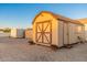 Tan shed features double doors with decorative cross, single entry door, and window at 11138 W Hatcher Rd, Sun City, AZ 85351