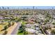 Expansive aerial view of a neighborhood with mature palm trees and city buildings on the horizon at 1129 W Holly St, Phoenix, AZ 85007