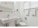 Cozy bathroom with a pedestal sink, toilet, and a glass shelf for storage at 1129 W Holly St, Phoenix, AZ 85007