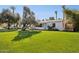 Single story home with white brick, a blue door, and lush green front lawn at 1129 W Holly St, Phoenix, AZ 85007