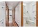 Inviting hallway with hardwood floors leads to a bathroom with charming checkered tiles at 1129 W Holly St, Phoenix, AZ 85007