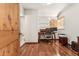 A home office with hardwood floors and a wooden door leading to a bright, tiled bathroom at 1129 W Holly St, Phoenix, AZ 85007