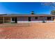 Gravel backyard with partial view of the home's exterior, including siding, windows, and covered patio at 11451 S Half Moon Dr, Phoenix, AZ 85044