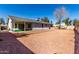 Exterior view showcasing a gravel backyard, covered patio, and the home's siding at 11451 S Half Moon Dr, Phoenix, AZ 85044