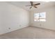 Spacious bedroom featuring a ceiling fan and natural light from the window at 11451 S Half Moon Dr, Phoenix, AZ 85044