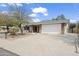 Inviting home exterior with a two-car garage, brick accents, and a mature landscape at 11451 S Half Moon Dr, Phoenix, AZ 85044