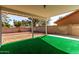 View of a covered patio with bright green turf and a block wall, creating a relaxing outdoor space at 11451 S Half Moon Dr, Phoenix, AZ 85044