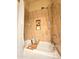 Close-up on the bathtub with designer tile, a relaxing shower head, and decorative items at 11640 N Tatum Blvd # 3074, Phoenix, AZ 85028
