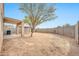 View of the backyard with block wall, covered patio, and open space at 11765 W Maui Ln, El Mirage, AZ 85335