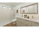 Contemporary bathroom featuring double sinks, and tiled shower with glass doors at 11765 W Maui Ln, El Mirage, AZ 85335