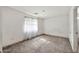 Bright bedroom featuring neutral carpet, sheer curtains, and ample natural light at 11765 W Maui Ln, El Mirage, AZ 85335